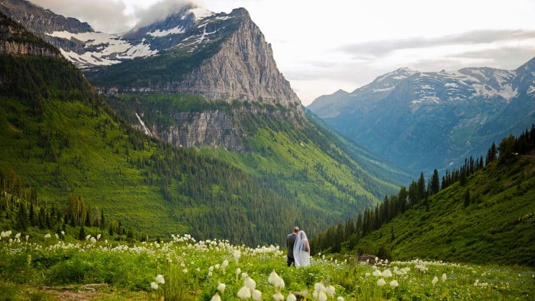 Wedding couple having their photos taken in glacier national park, rocky mountains, montana1600x900